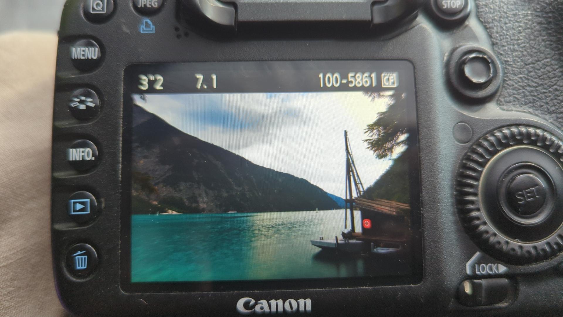 A weird floating platform at the side of a beautiful lake, surrounded by massive mountains